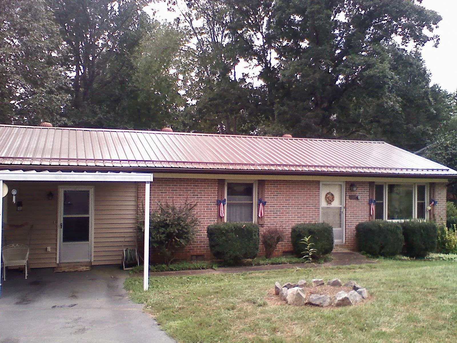 Bronze metal roof and carport on a brick ranch home — Roof Repair work by our crew in Lubbock